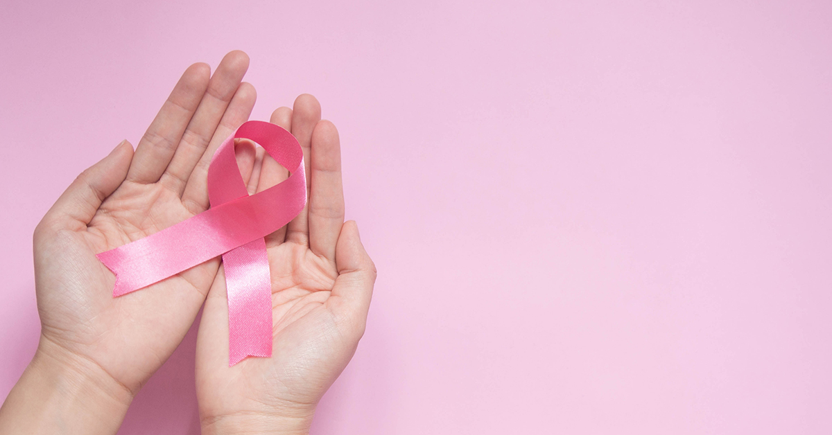 International symbol of Breast Cancer Awareness Month in October. Close up of female hand holding satin pink ribbon awareness on pink background w/ copy space. Women's health care and medical concept.; blog: 9 Ways to Reduce Your Risk of Breast Cancer